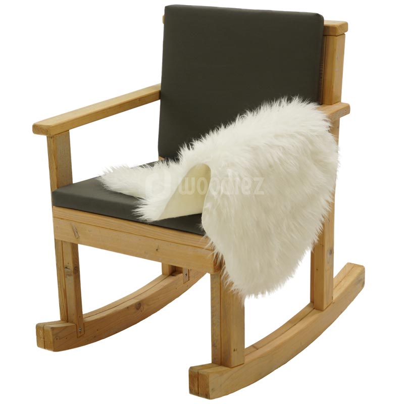 Moderne steigerhouten schommelstoel aangekleed met schapenvacht